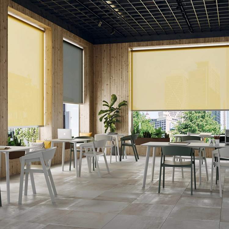 Estores enrollables instalados en cafetería con gran entrada de luz natural