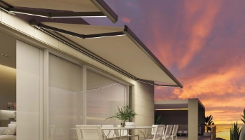 Toldo beige extensible instalado en terraza moderna de Zaragoza al atardecer, con sistema de brazos articulados
